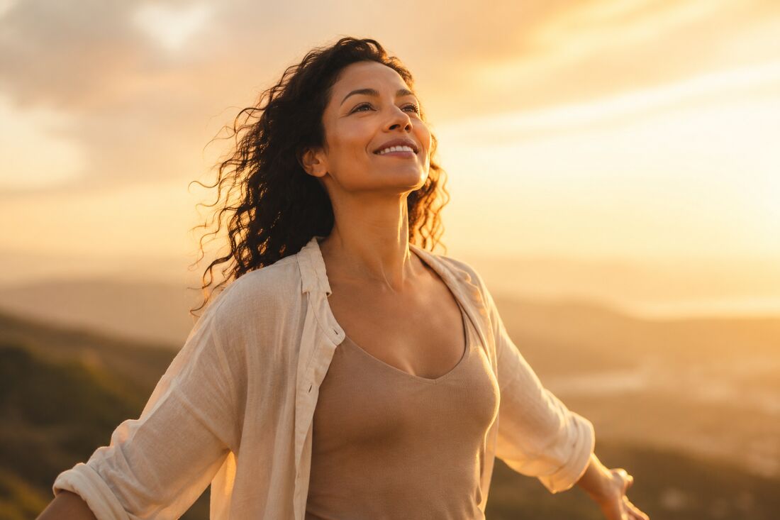 A woman standing tall in golden light, arms open, remembering who she is